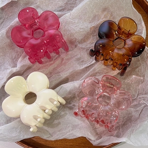 Set of four floral hair claws in pink, amber, and cream colors for sweet hair styling