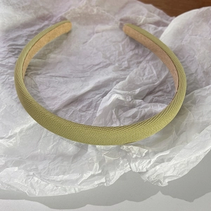 Détail d'un serre-tête en tissu vert clair avec une doublure intérieure antidérapante
