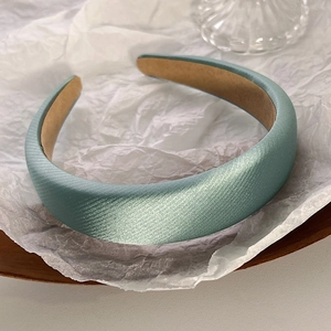 Close-up of mint green padded sponge headband with premium diagonal satin texture