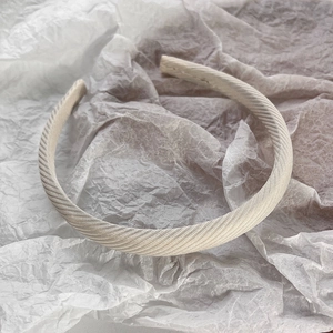 Vue détaillée de la texture du tissu sergé beige sur un serre-tête rembourré doux