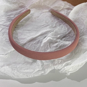 Détail du serre-tête en tissu rose avec une texture de doublure intérieure beige