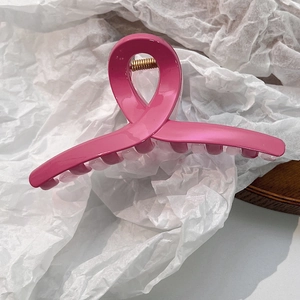 Détail de la grande pince à cheveux rose vif avec ressort en métal doré robuste