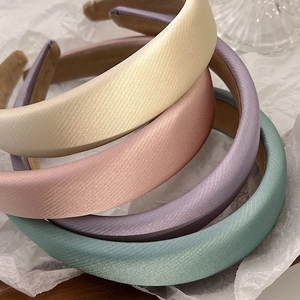 Close-up of pastel sponge headbands showing soft satin texture and non-slip velvet lining