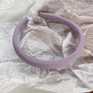 Détail d'un serre-tête en tissu lilas avec texture croisée et rembourrage en éponge douce
