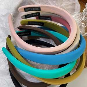 Detail of colorful sponge headbands with handmade woven labels and soft fabric textures