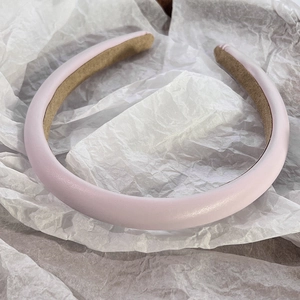 Close-up of pink padded leather headband with soft anti-slip lining and matte finish