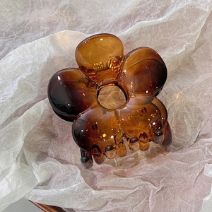 Detailed view of amber flower hair claw clip with translucent acrylic finish