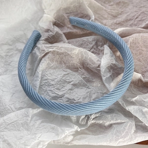 Détail d'un serre-tête en tissu plissé bleu clair avec texture vintage et couture fine