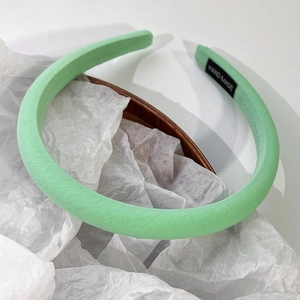 Détail du serre-tête en tissu vert menthe avec étiquette faite main et armure sergé