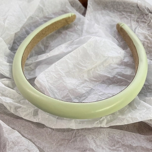 Detailed close-up of light green PU leather headband with anti-slip brown suede lining