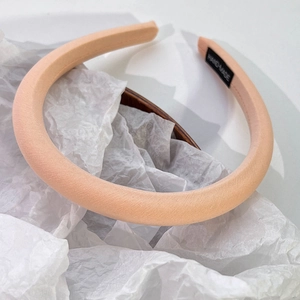 Vue détaillée du serre-tête en satin rose crème montrant l'étiquette en tissu fait main