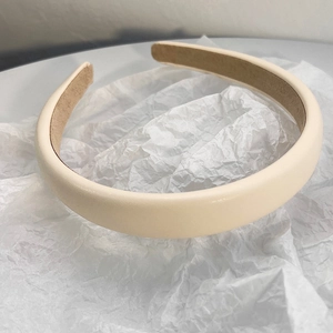 Macro view of the beige faux leather sponge headband featuring brown velvet non-slip lining