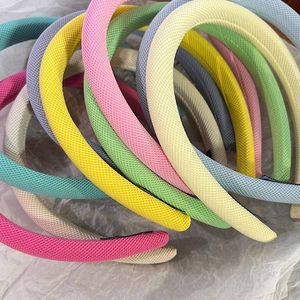 Détail de serre-têtes en éponge colorés avec tissu texturé aux tons de macaron