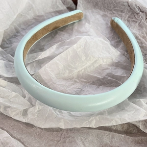 Detailed view of light blue padded headband with smooth PU leather texture and non-slip lining