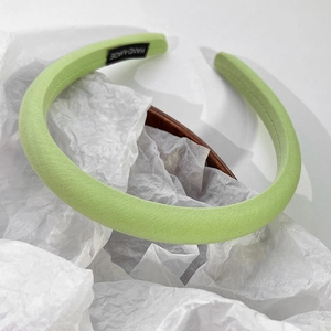 Détail du serre-tête rembourré vert citron avec étiquette fait main et texture fine