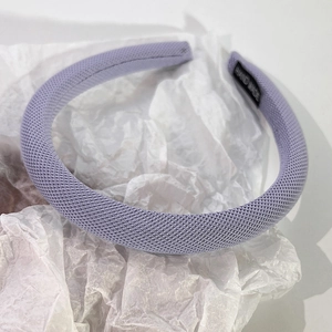 Gros plan sur un serre-tête en tissu tissé violet clair avec étiquette faite main