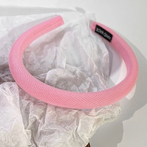 Détail macro du serre-tête en tissu rose épais avec étiquette tissée fait main