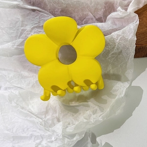 Nahaufnahme der mattgelben Blumen-Haarklammer mit gefrosteter Harztextur und Federzähnen