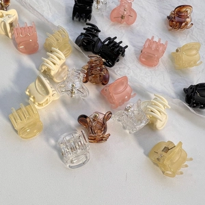 Mini plastic claw clips in various colors including pink and amber for girls' hairstyles