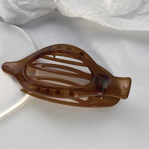 Dettaglio di una pinza per capelli francese marrone traslucido con molla in metallo forte