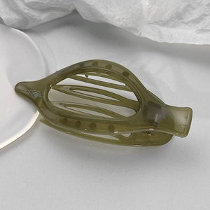 Dettaglio del fermaglio per capelli in resina verde oliva con elegante design curvo cavo