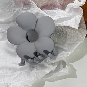 Nahaufnahme der matten, staubblauen Blumen-Haarklammer mit Textur und 3D-Design