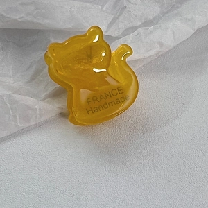 Détail de la pince à cheveux chat jaune ambre avec texte France Handmade sur papier blanc
