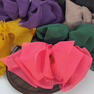 Oversized multi-color chiffon bow hair clips on a wooden tray for women's hair styling