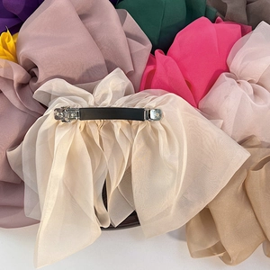 Close-up of elegant oversized chiffon bow hair clip with silver spring metal mechanism