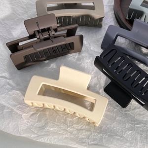 Detail view of large matte rectangular hair claws in various elegant neutral colors