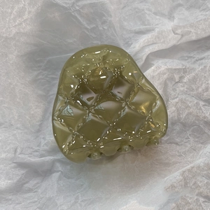 Détail de la pince à cheveux vert olive en résine avec motif en relief à losanges
