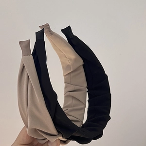Detailed view of black and beige pleated headbands with comfortable wrapped ends