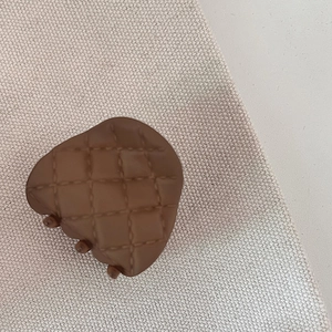 Close-up of heart-shaped chocolate brown hair claw with quilted lattice matte finish