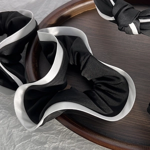 Vintage black and white scrunchie and headband set with silk texture in a wooden tray