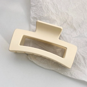 Close-up of matte beige rectangular hair claw clip with cutout design on tissue paper
