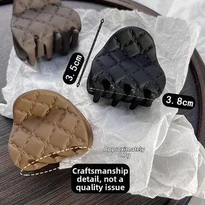 Detail showing matte quilted grid hair claws in black and brown colors with 3.8cm size
