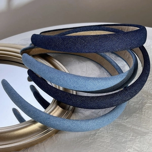 Elegant denim sponge padded headband set in various blue washes on a vintage mirror