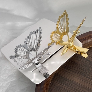 Detailed view of hollow metal butterfly hair clips in gold and silver finish