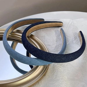 Close-up of thick sponge headbands in dark and light denim blue on a mirror