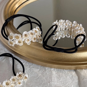 Elegant French-style floral pearl hair scrunchies with white beads on gold-rimmed mirror