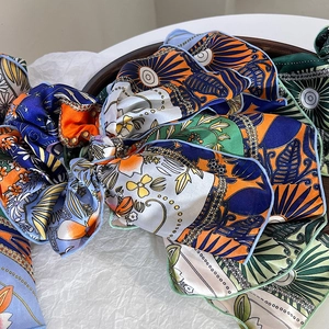 Bohemian silk-style floral scrunchies with long ribbons in vibrant orange and blue patterns