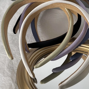 Elegant wide satin sponge headbands in Morandi colors displayed on a gold mirror frame