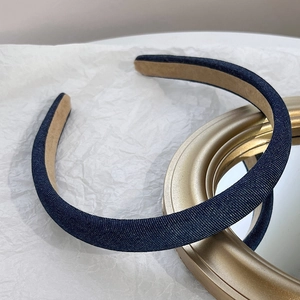 Detailed view of dark blue denim headband with soft brown suede inner lining fabric