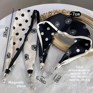 Détail du foulard en satin français avec boules aimantées diamantées et roses