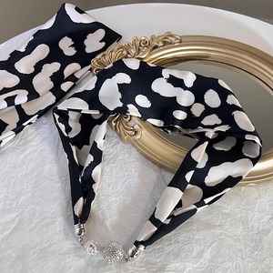 Détail du collier foulard en soie à pois noir et blanc avec boules ornées de cristaux