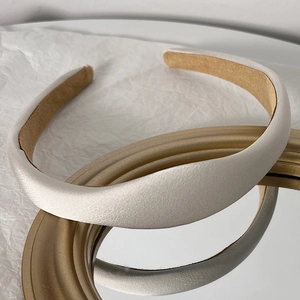 Detailed view of cream satin padded headband with premium non-slip brown suede lining
