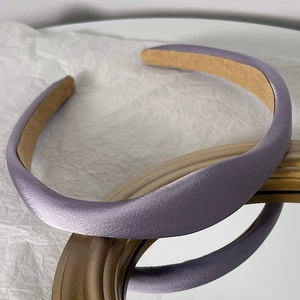 Close-up of lavender padded satin headband with soft anti-slip lining on white background