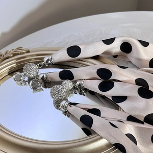 Detail of champagne satin polka dot scarf with crystal encrusted magnetic metal accents