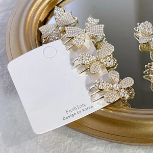 Elegant 4-piece pearl hair clip set with butterfly and flower designs on gold alloy base