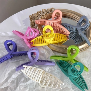 Grandes pinces à cheveux colorées mates aux tons pastels sur un fond artistique élégant